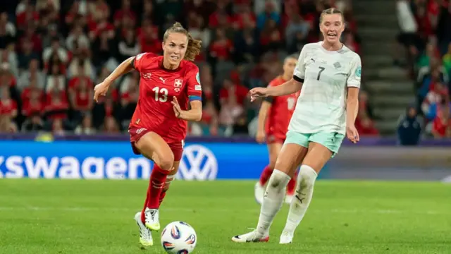 Lia Walti of Switzerland (L) runs with the ball under pressure from Karolina Lea Vilhjalmsdottir