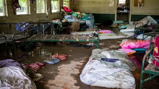 Mattresses and rubbish scattered inside a cabin at Camp Mystic