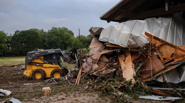 An excavator near a giant pile of rubble