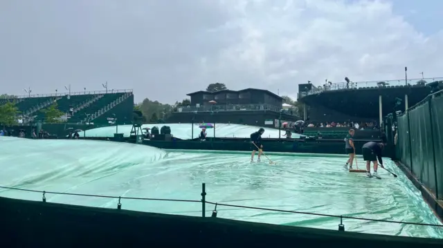 Ground staff cover the courts