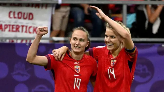 Norway's forward #10 Caroline Graham (L) celebrates after scoring a goal with teammate Norway's forward #14 Ada Hegerberg (R) during the UEFA Women's Euro 2025 Group A football match between Norway and Finland at the Stade de Tourbillon