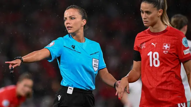 Spanish referee Marta Huerta De Aza gestures as she hold the hand of Switzerland's defender #18 Viola Calligaris during the UEFA Women's Euro 2025 Group A football match between Switzerland and Iceland at the Wankdorf stadium