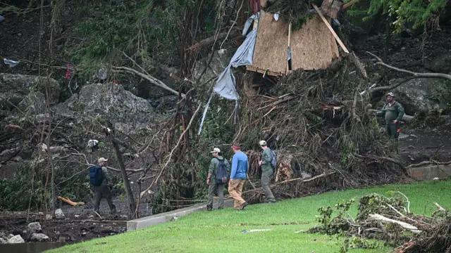 A search and rescue team inspecting wreckage caused by the flood