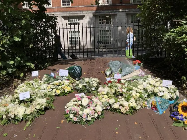 Wreaths are laid at Tavistock Square. There are white roses as well as sunflowers