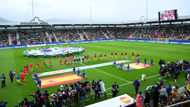 Spain and Belgium players line up prior to kick-off for the national anthem