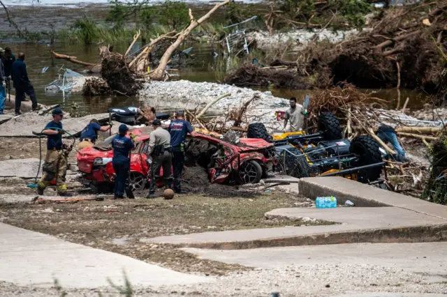 First responders attend to destroyed and overturned vehicles pulled from water in the aftermath of deadly flooding in Kerrville, Texas
