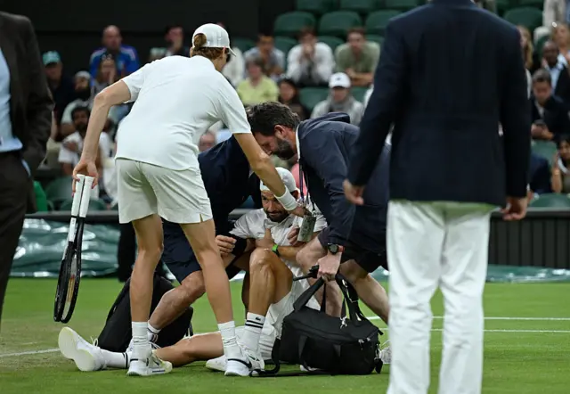 Grigor Dimitrov is helped to his feet
