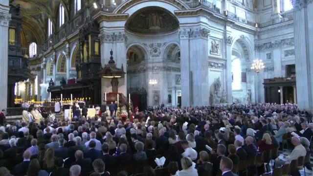 People sit in chairs at St Paul's during a memorial service