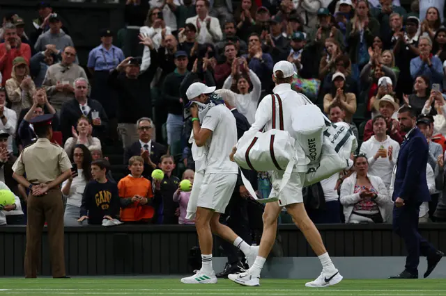 Jannik Sinner carries Grigor Dimitrov's bags off for him