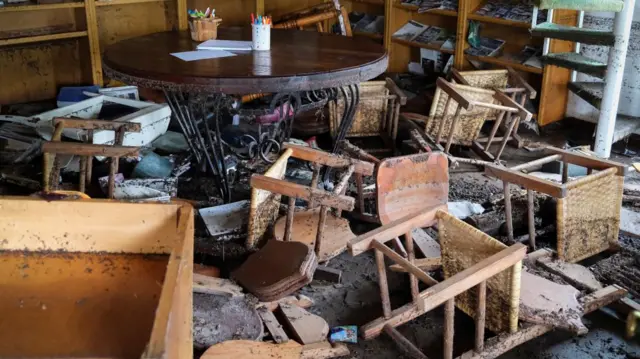 Chairs lie on the floor in a damaged room