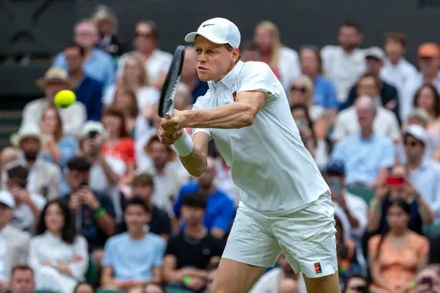 Jannik Sinner in the action of hitting a tennis ball