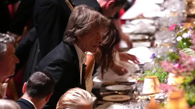Mick Jagger sitting at a table