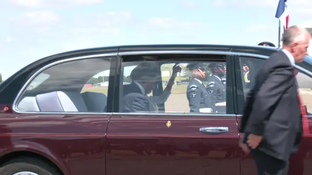 A man sitting in a fancy red car with his back to the camera