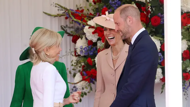 Kate , William and Brigitte smile on stage.