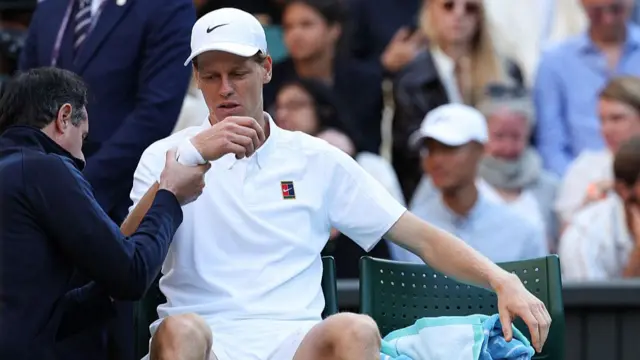 Jannik Sinner gets elbow checked by trainer at Wimbledon