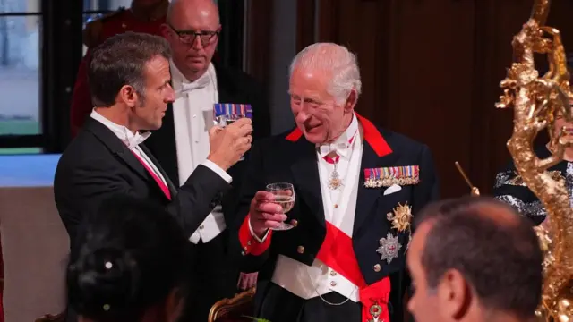Macron and King Charles raising a glass to each other
