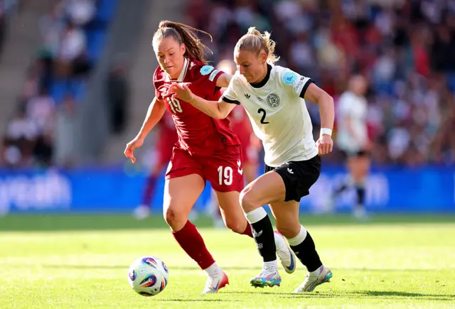 Sarai Linder of Germany runs with the ball whilst under pressure from Janni Thomsen