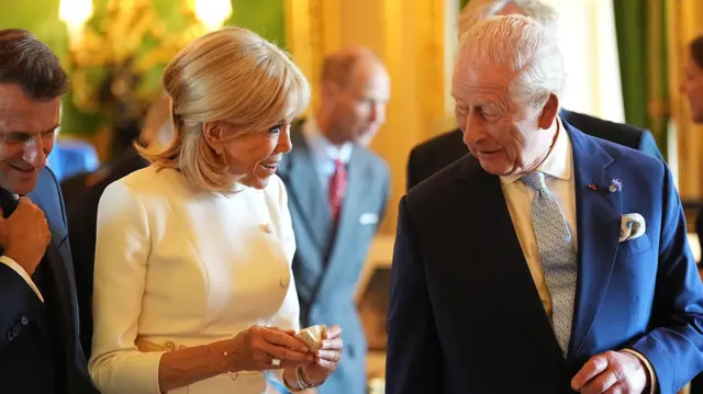 King Charles III (right) with the President of France Emmanuel Macron and his wife Brigitte Macron view items on display during a visit to the Royal Collection exhibition, in the Green Drawing Room at Windsor Castle, Berkshire, on day one of the French President's state visit to the UK