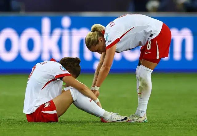 Poland players console one another at full time