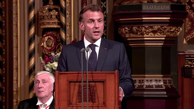 Macron speaking at a podium