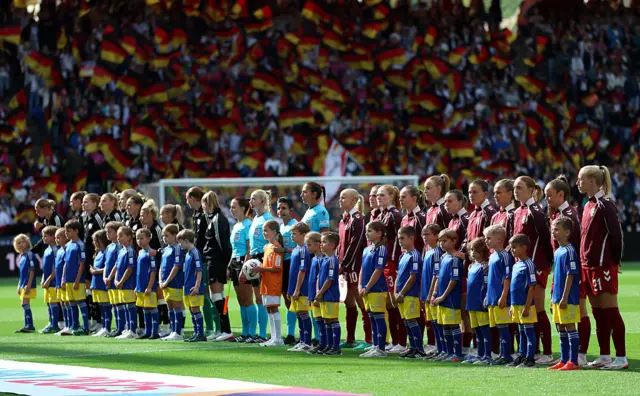 The match officials and players of Germany and Denmark line up