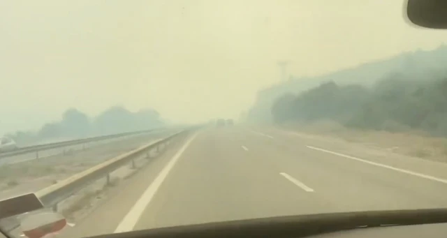 Footage taken from a moving vehicle showing a smoke haze across a main road south of Marseille