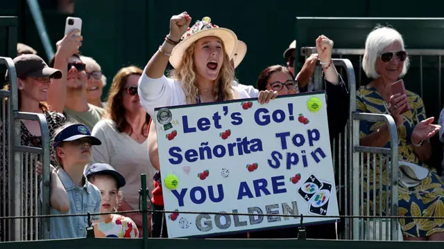 Mirra Andreeva holds up sign in support if coach Conchita Martinez