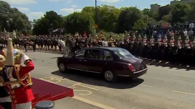 Car driving past crowds