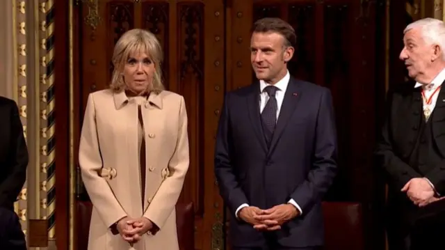 Macron, standing next to his wife and Speaker Lindsay Hoyle
