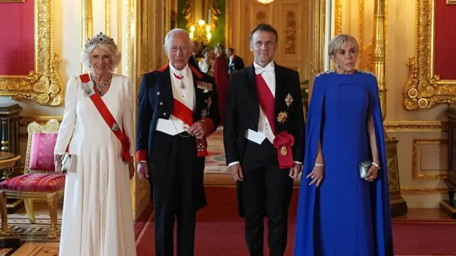 Queen Camilla, King Charles, French President Emmanuel Macron and wife Brigitte Macron stand next to each other posing to the camera