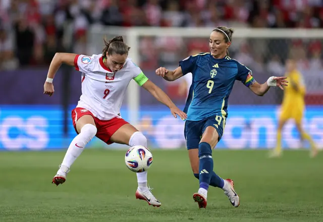 Ewa Pajor of Poland controls the ball whilst under pressure from Kosovare Asllani