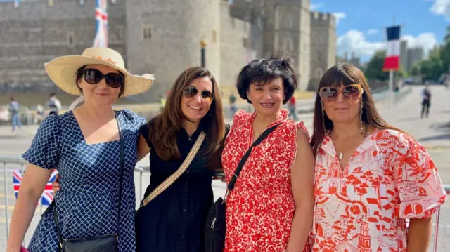 Four women pose for camera in front of Windsor Castle