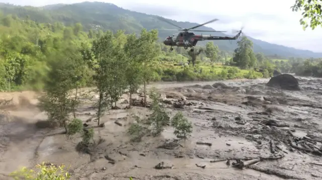 This screengrab from one of the videos shows the army helicopter hovering over the rushing flooded river