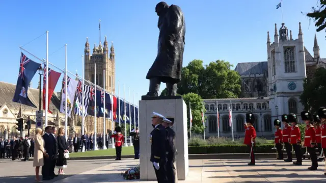 Macron and Starmer stand with their wives after laying a wreath at the statue of former British Prime Minister Winson Churchill in Parliament Square
