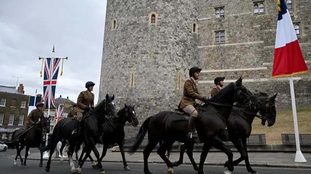 Horses are ridden past Windsor Castle in Windsor, west of London on July 6, 2025, ahead of a state visit by French President Emmanuel Macron and his wife Brigitte Macron.