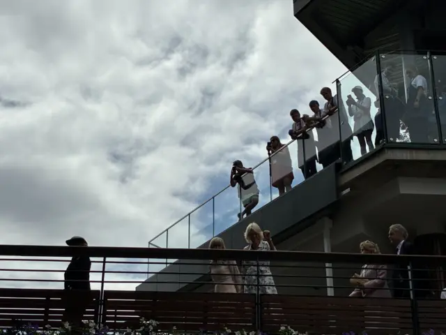 The Queen walks across footbridge