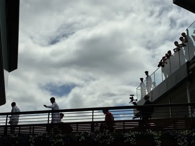 Novak Djokovic walks across footbridge