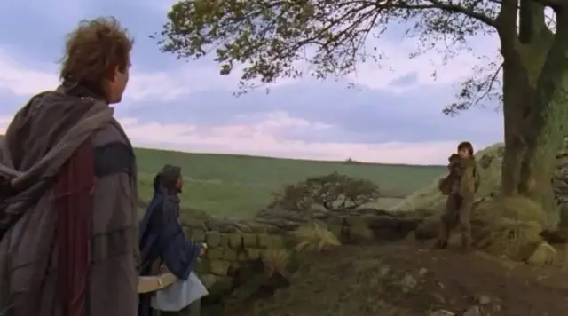 A still from Robin Hood film with Kevin Costner and Morgan Freeman in medieval costumes talking to a young boy, who is wearing brown clothes, standing next to the three