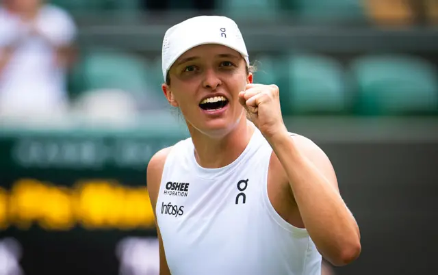 Iga Swiatek holds up her fist to celebrate
