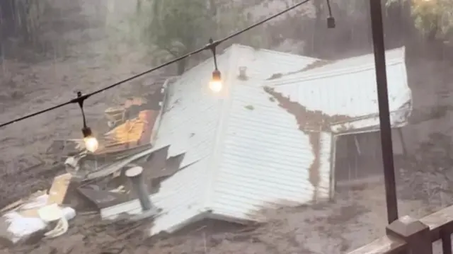 A screengrab from a video obtained by the Reuters news agency showing a house in Ruidoso being washed away in the flood