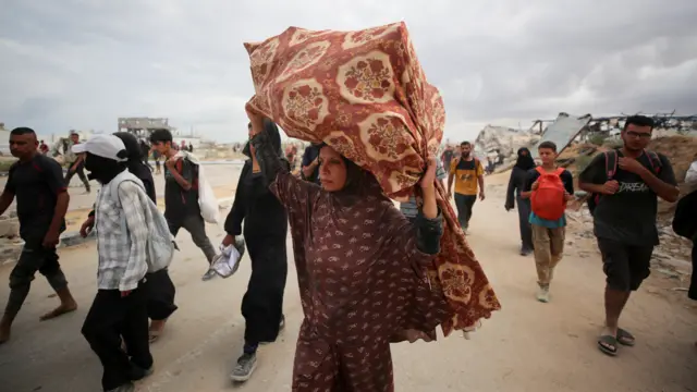 Palestinians carry aid supplies which they received from the U.S.-backed Gaza Humanitarian Foundation (GHF)