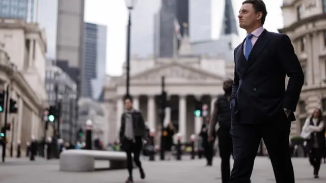Commuters walk in City of London financial district in London, Britain