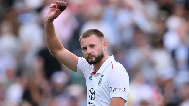 Gus Atkinson holds a ball in celebration after taking a wicker vs India,