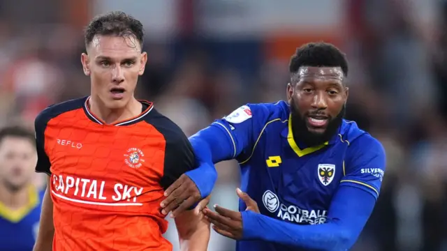 Luton Town's Kal Naismith (left) and AFC Wimbledon's Myles Hippolyte battle for the ball