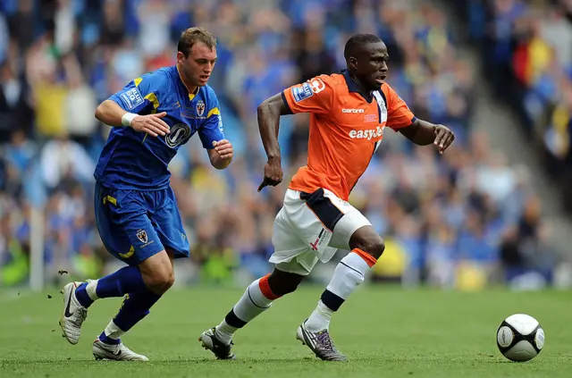 Brett Johnson of AFC Wimbledon chases Claude Gnakpa of Luton Town