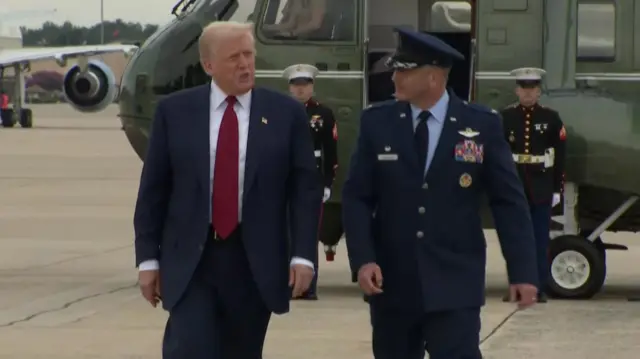 Donald Trump on tarmac with military officer