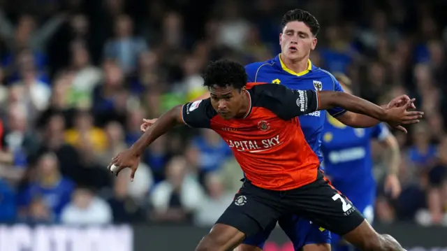 Luton Town's Reuell Walters (left) and AFC Wimbledon's Mathew Stevens battle for the ball
