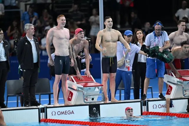Tom Dean (L), Matthew Richards (C), James Guy (R), and Duncan Scott (ground) of Great Britain Team celebrate