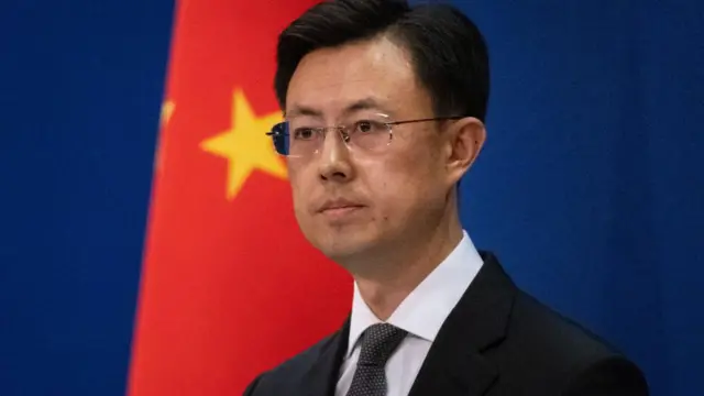 A close up of Guo Jiakun, who stands in front of the Chinese flag at a news conference