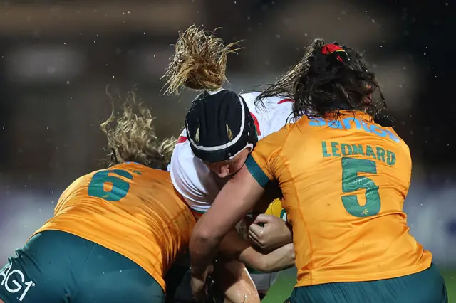 Bethan Lewis is tackled by two players